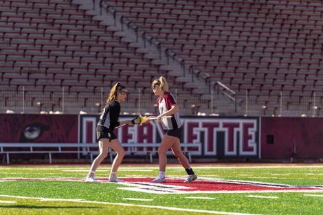 Two lacrosse players on the field.