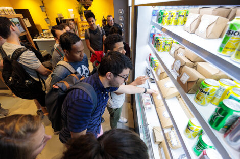 Students grab food from a shelf.